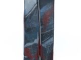 un vase noir orné d'un motif rouge et bleu