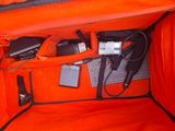 an orange bag with electronics inside of it on the ground