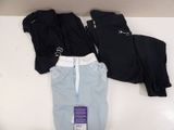three pairs of black and blue pants on a white table