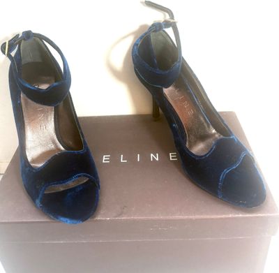 une paire de chaussures bleues posée sur une boîte, elle-même posée sur une surface blanche