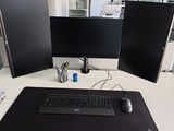 a desk with two monitors and a keyboard on it