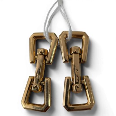 pair of gold tone metal earrings with a white cord