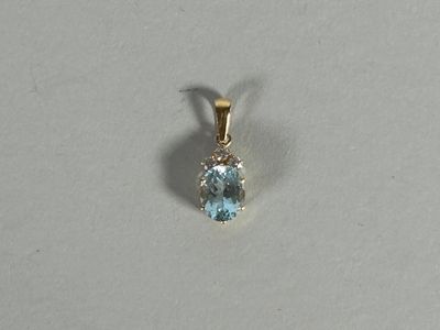 a close up of a blue topaz stone pendant on a white surface