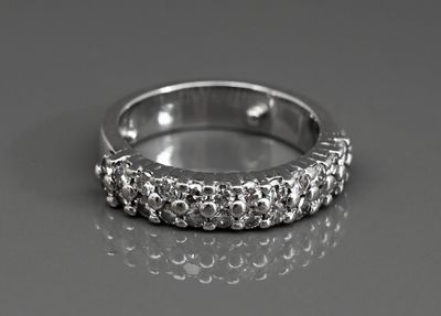 une image d'une bague en diamant sur une surface réfléchissante