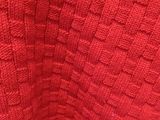 a close up of a red sweater with a pattern on it