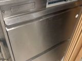 a silver dishwasher sitting on top of a counter in a kitchen