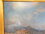 une peinture accrochée au mur d'un immeuble, avec une montagne en arrière-plan