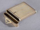 a small metal box with a small metal object inside of it