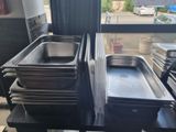 several trays of food sit on a table in front of a window
