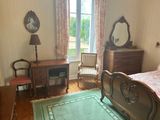 a bedroom with a bed, dresser, mirror, and chair in it