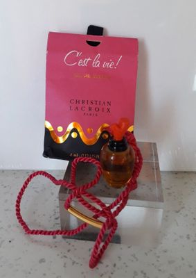 un flacon de parfum à côté d'un sac rose