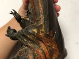 someone is holding a statue of a person with a bird on it ' s back