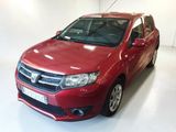 La voiture rouge est garée dans une pièce blanche au sol blanc.