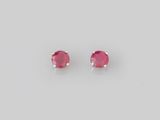 une paire de boucles d'oreilles à clous en saphir rose sur fond blanc