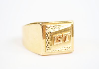 an image of a gold signet ring on a white surface