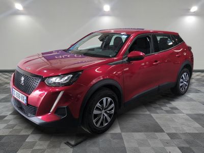 Un SUV rouge est garé dans une pièce dont le sol est en damier.