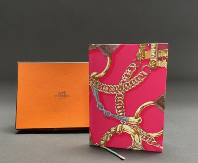 an orange and pink notebook with a gold chain on it