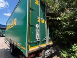 a green truck that is driving down the road