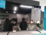 quelqu'un en train de prendre une photo d'un téléviseur à écran plat dans un magasin