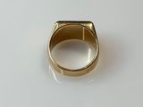 a close up of a gold ring on a white surface