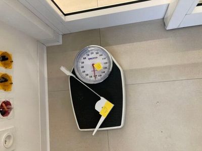 une salle de bains équipée d'un pèse-personne et de toilettes