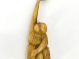 an image of a wooden sculpture of a monkey holding a ball
