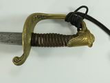 a sword with a gold handle on a white surface
