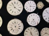 many different types of clocks displayed on a black surface