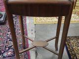 a small wooden table with a lamp on top of it