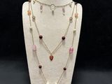 a white mannequin necklace with multi colored stones and pearls