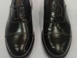 pair of black leather shoes with laces on them on a white surface