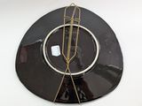 a black and gold plate with a clock on it