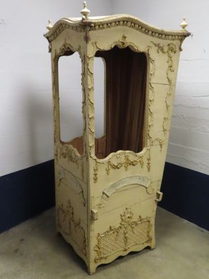 une armoire en bois surmontée d'un baldaquin, placée dans un coin de la pièce