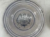 a plate with a flower design on it next to a plate with a flower design on it