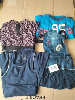 trois vêtements posés sur une boîte en carton