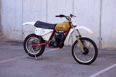 a dirt bike parked in a parking lot next to a wall