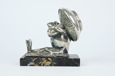 figurine en argent représentant une grenouille coiffée d'un chapeau et tenant un parapluie, posée sur un socle en marbre