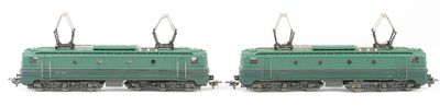 two green trains sitting side by side on a white surface