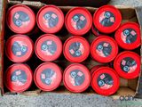 a box full of red cans of soda sitting on the ground