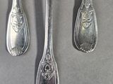 four spoons and two forks on a table