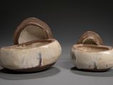 two pieces of pottery that are sitting on a table