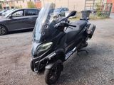 une moto noire garée sur un parking à côté d'une voiture noire