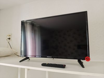 a flat screen tv sitting on top of a white shelf