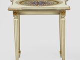 une table blanche dont le plateau est orné d'un motif bleu et or