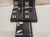 six boxed boxes of all blacks cigarettes sitting on a bed