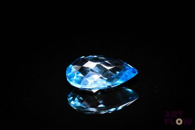 a close up of a blue topaz gems on a black surface