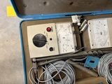 a blue case with wires and a meter in it