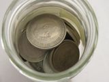 a jar full of coins sitting on a table