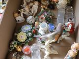 a cardboard box filled with assorted figurines on the floor
