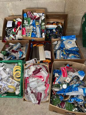 plusieurs cartons contenant des objets divers, posés par terre devant un mur